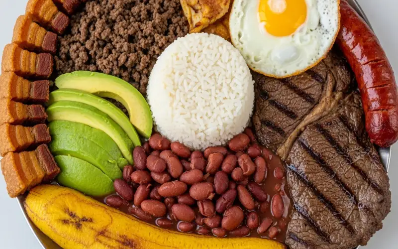 Close-up bandeja paisa platter with beans, rice, meats, egg, avocado