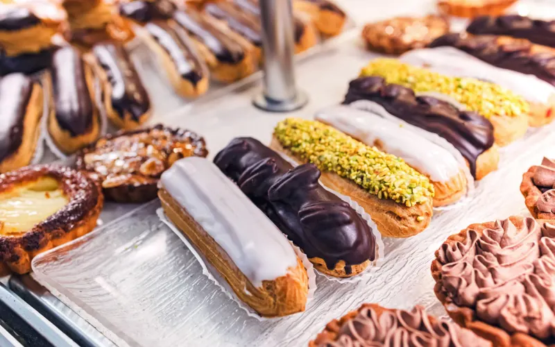 French pastry selection, mille-feuille layers, Paris-Brest ring pastry, chocolate éclairs, patisserie display.