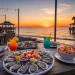 Orange Beach Alabama waterfront restaurants at sunset, seafood table with shrimp, oysters, and cocktails, beach view